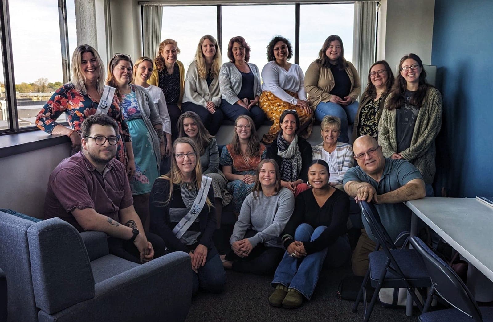 The Artful Life team — around twenty clinicians and staff gathered together, smiling, in their sunlit office.